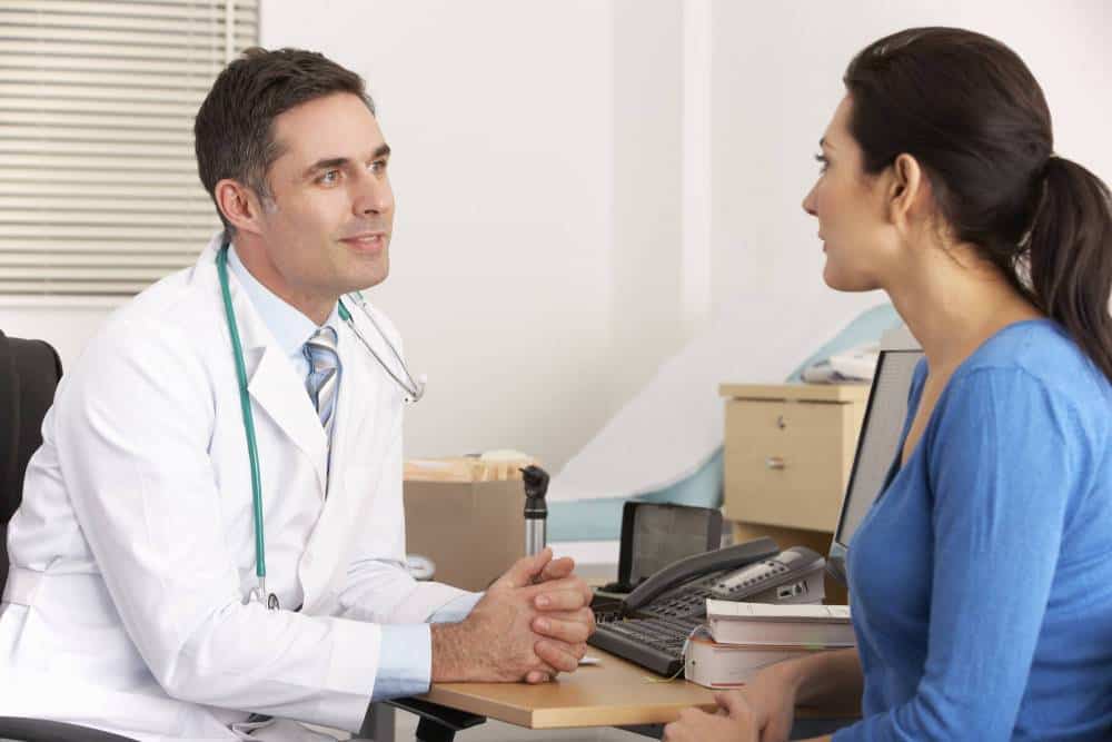 A doctor speaking to a patient in his office.